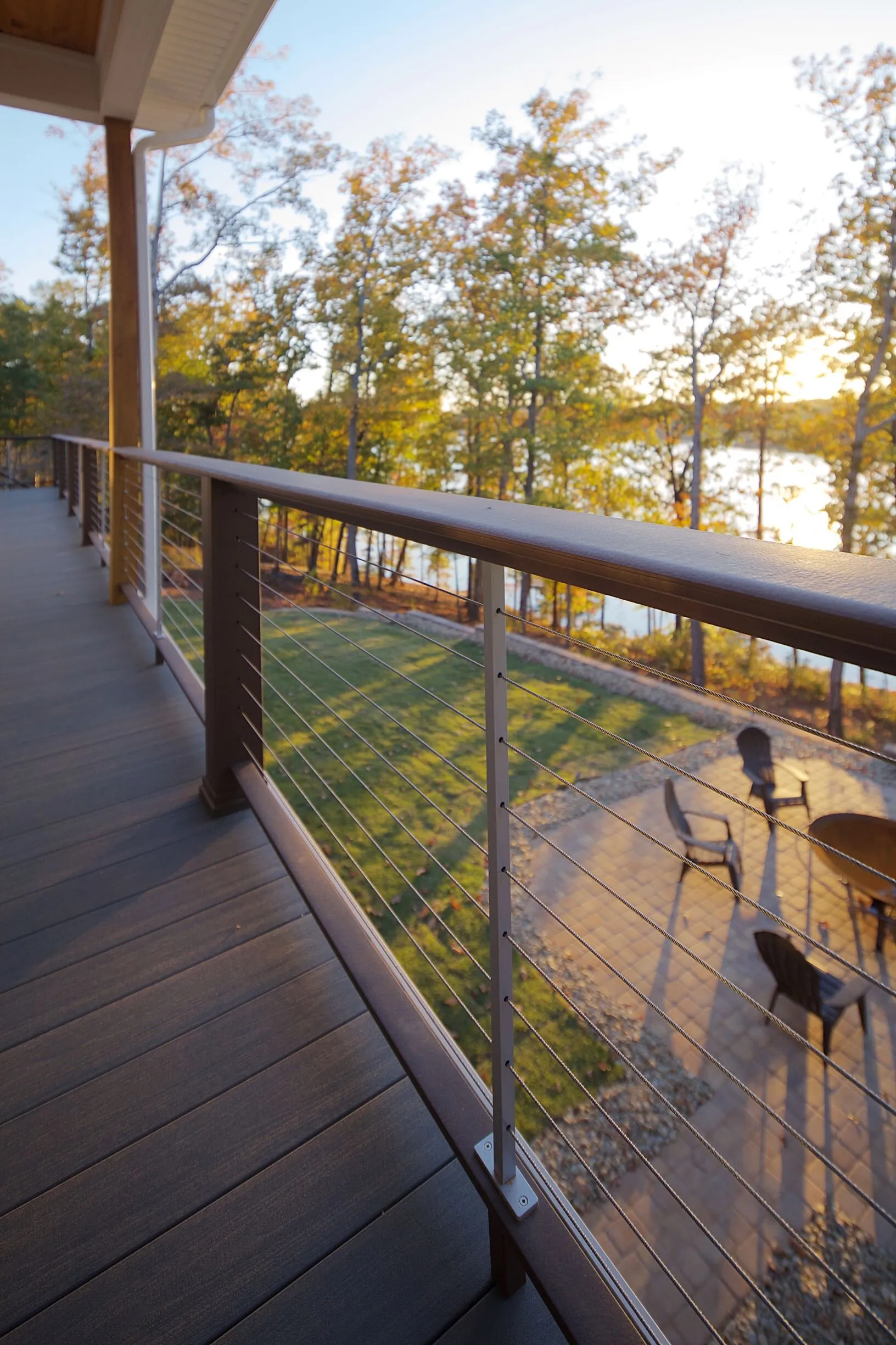 Close view along a cable-railed deck toward the lake at sunset