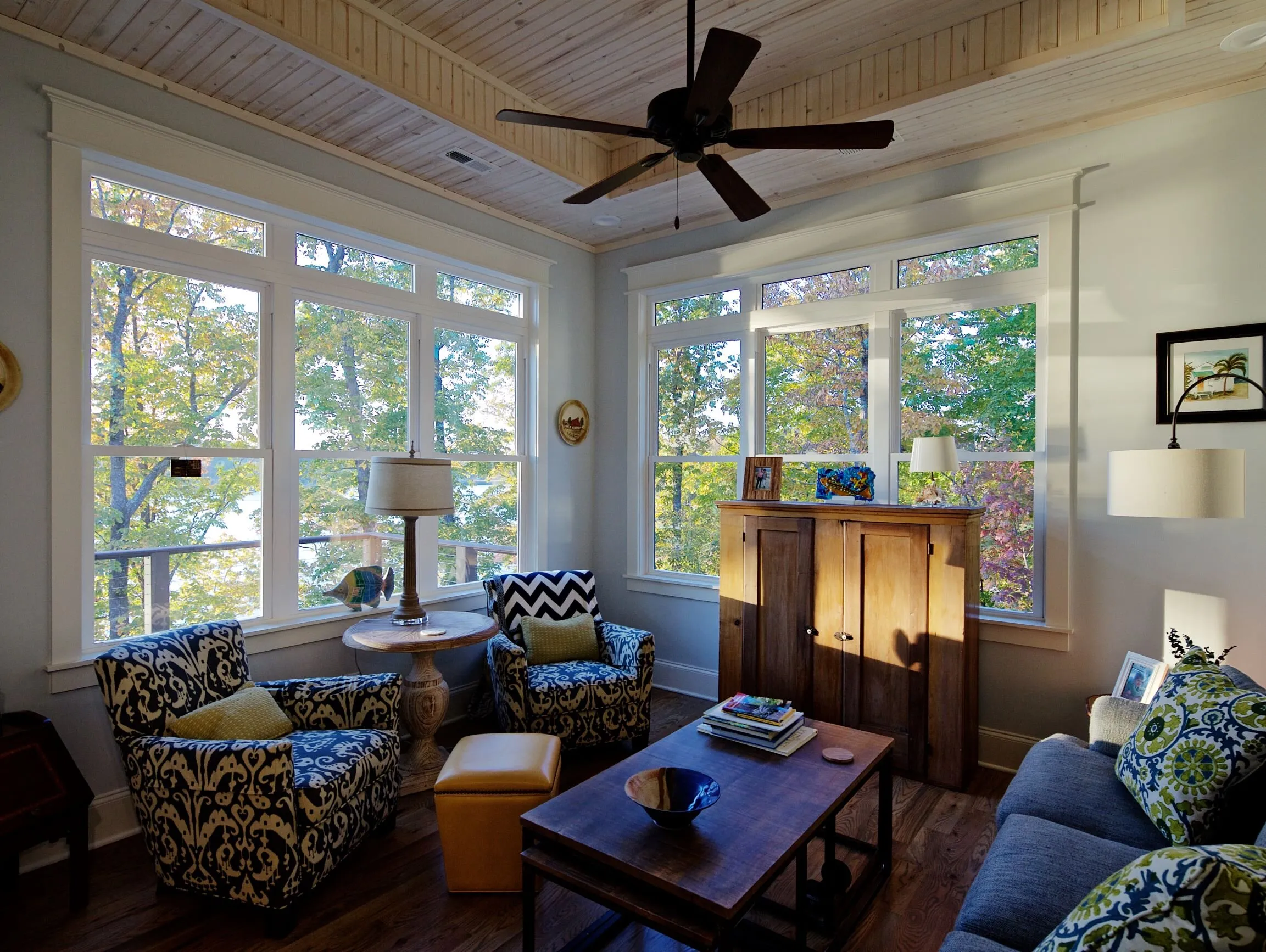 Sitting room wrapped by windows looking into trees