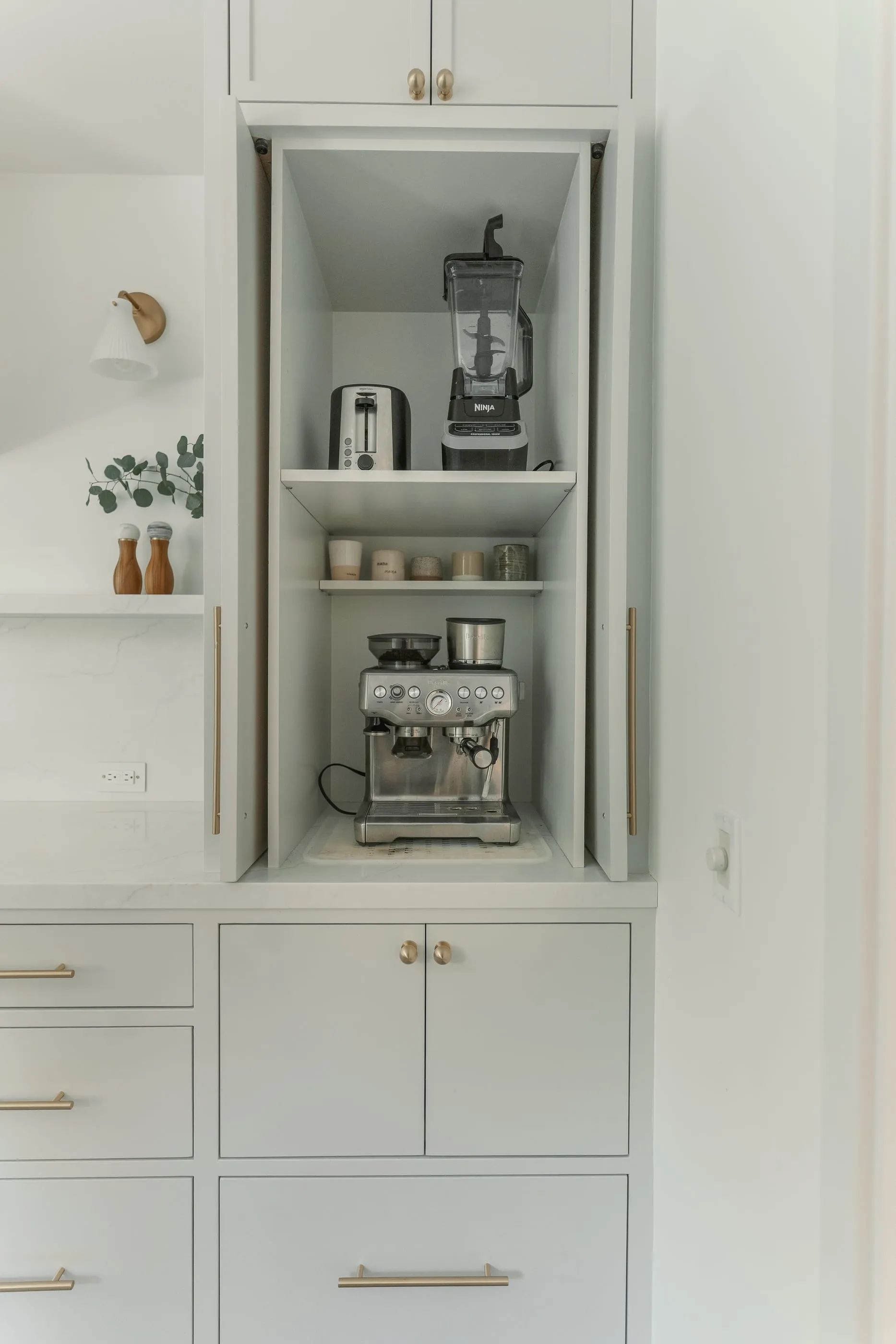 Tall cabinet opened to reveal an appliance garage and coffee station